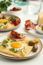 Photo of Delicious crepes with eggs and bacon served on white table, closeup