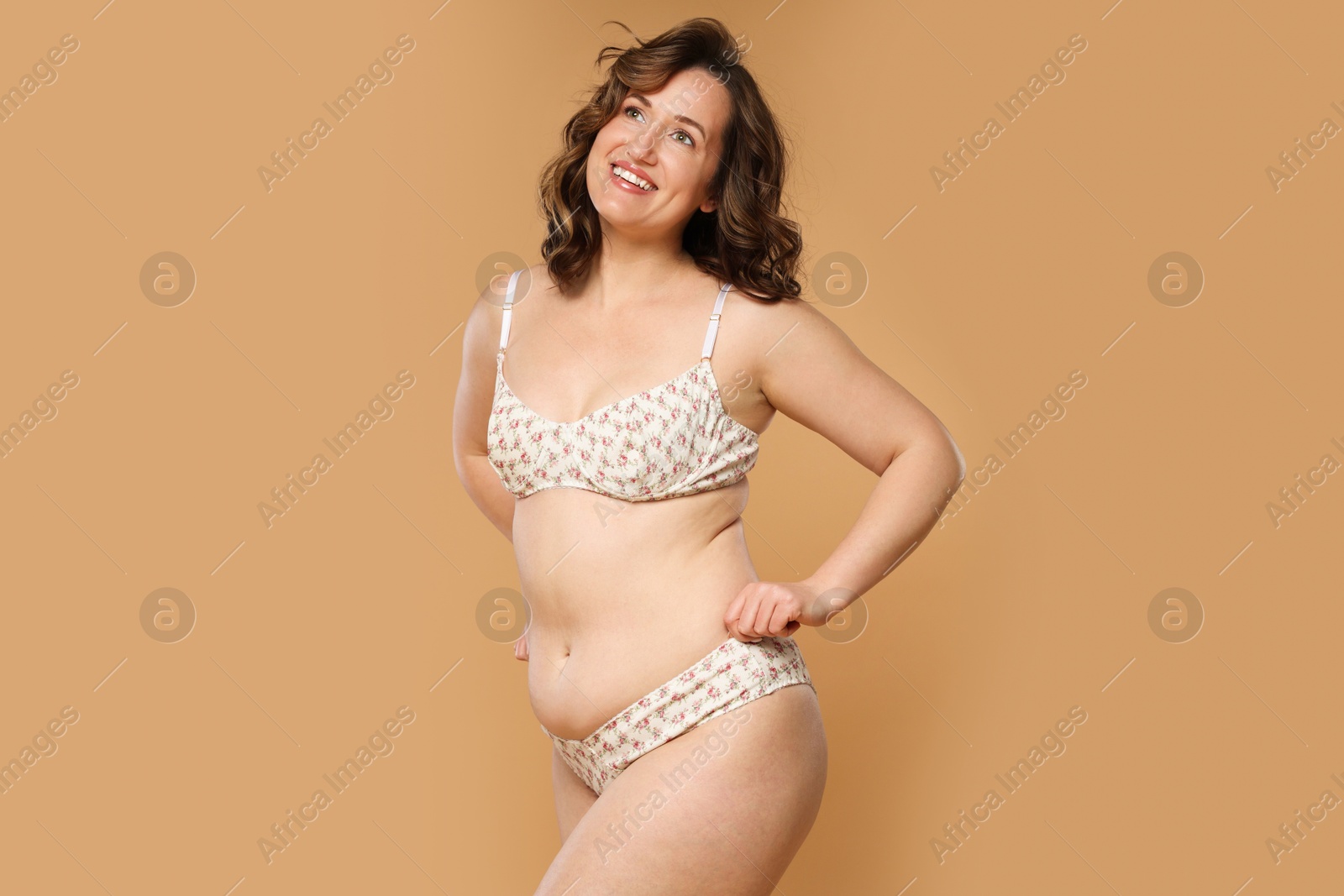 Photo of Beautiful woman in underwear on dark beige background. Cellulite problem