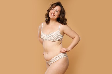 Photo of Beautiful woman in underwear on dark beige background. Cellulite problem