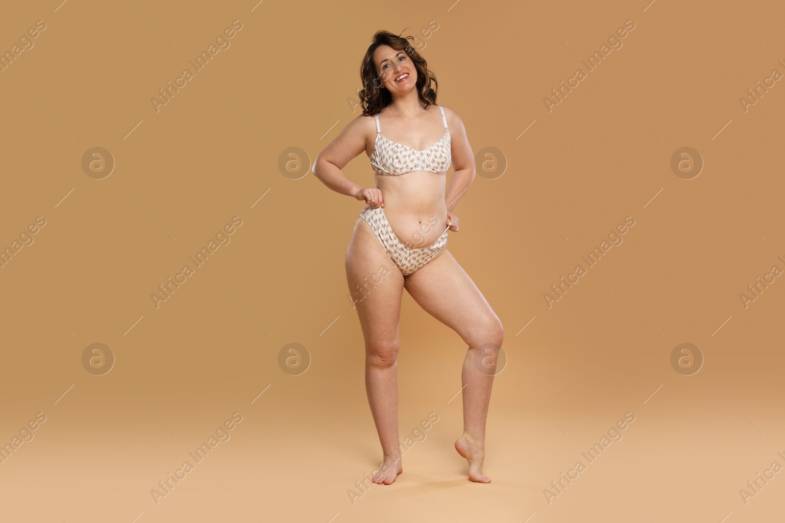 Photo of Beautiful woman in underwear on dark beige background. Cellulite problem