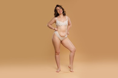 Beautiful woman in underwear on dark beige background. Cellulite problem