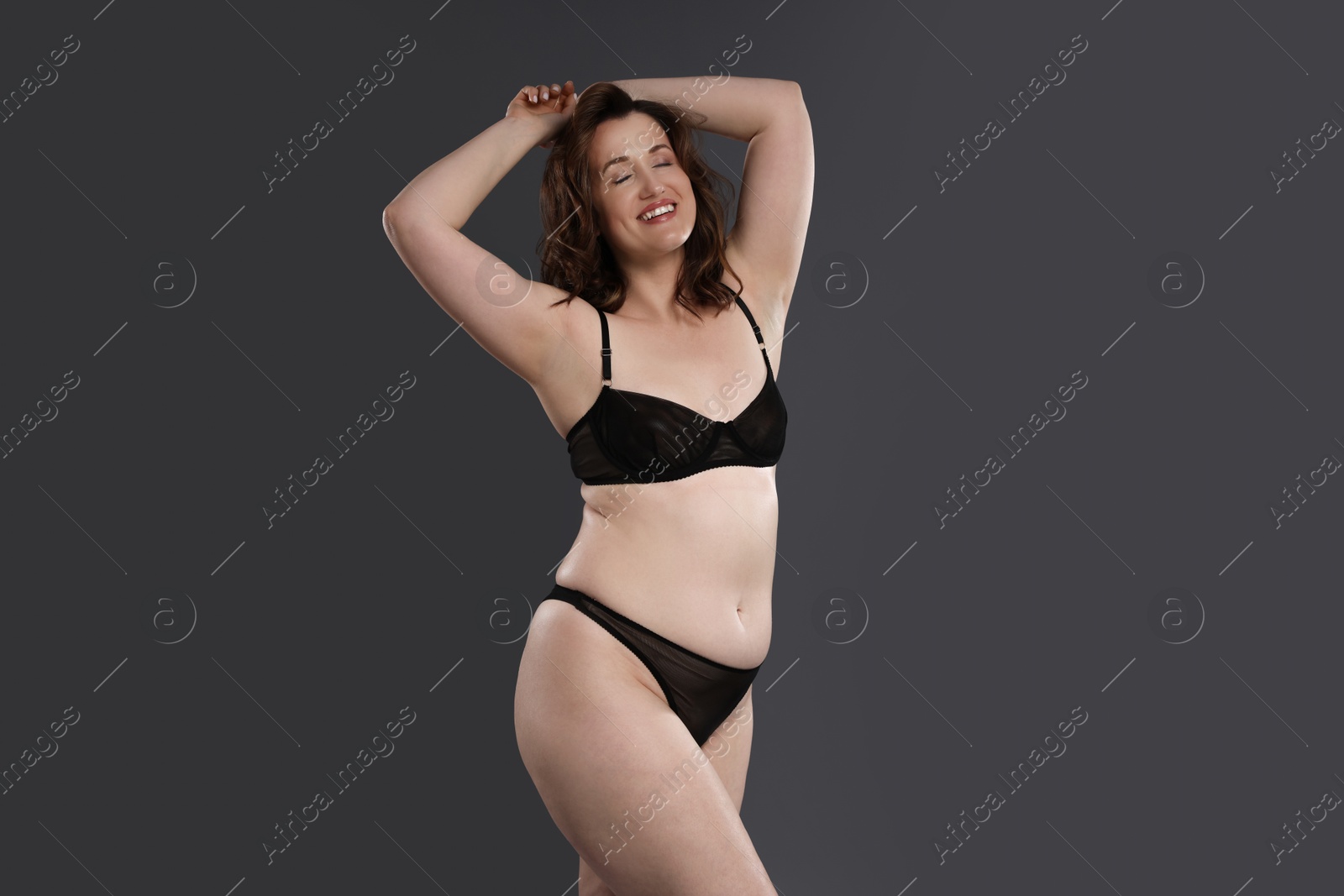 Photo of Beautiful woman in underwear on dark grey background. Cellulite problem