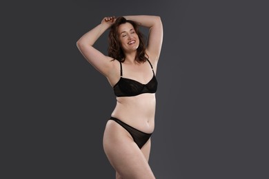 Photo of Beautiful woman in underwear on dark grey background. Cellulite problem