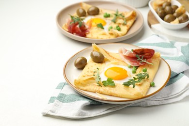 Photo of Delicious crepes with eggs and bacon served on white table, closeup. Space for text