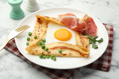 Photo of Delicious crepe with egg, bacon, arugula and green peas on white marble table, closeup