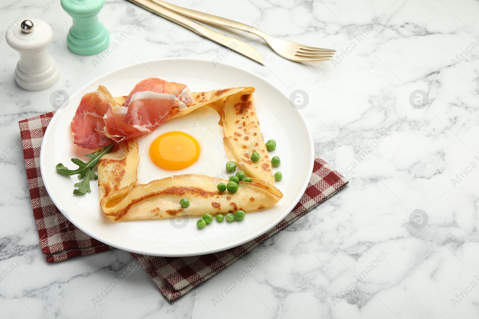 Photo of Delicious crepe with egg, bacon, arugula and green peas on white marble table, space for text