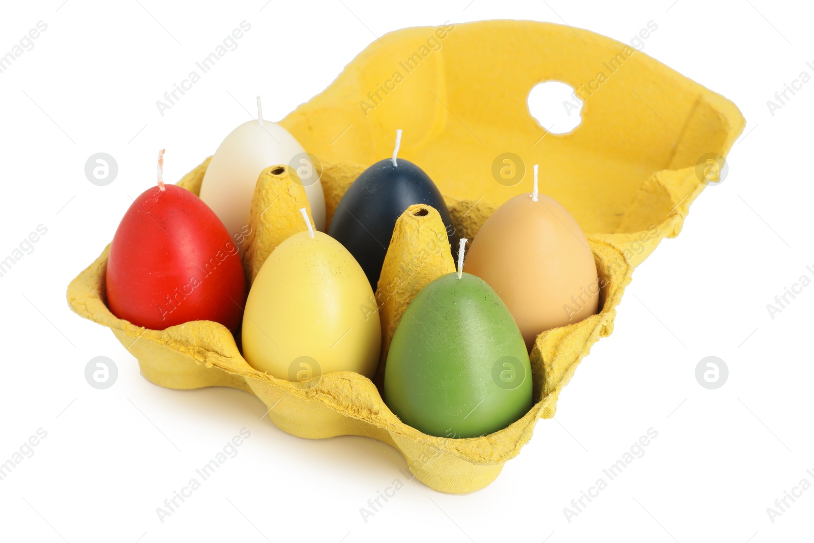 Photo of Colorful egg-shaped candles in carton isolated on white. Easter decor