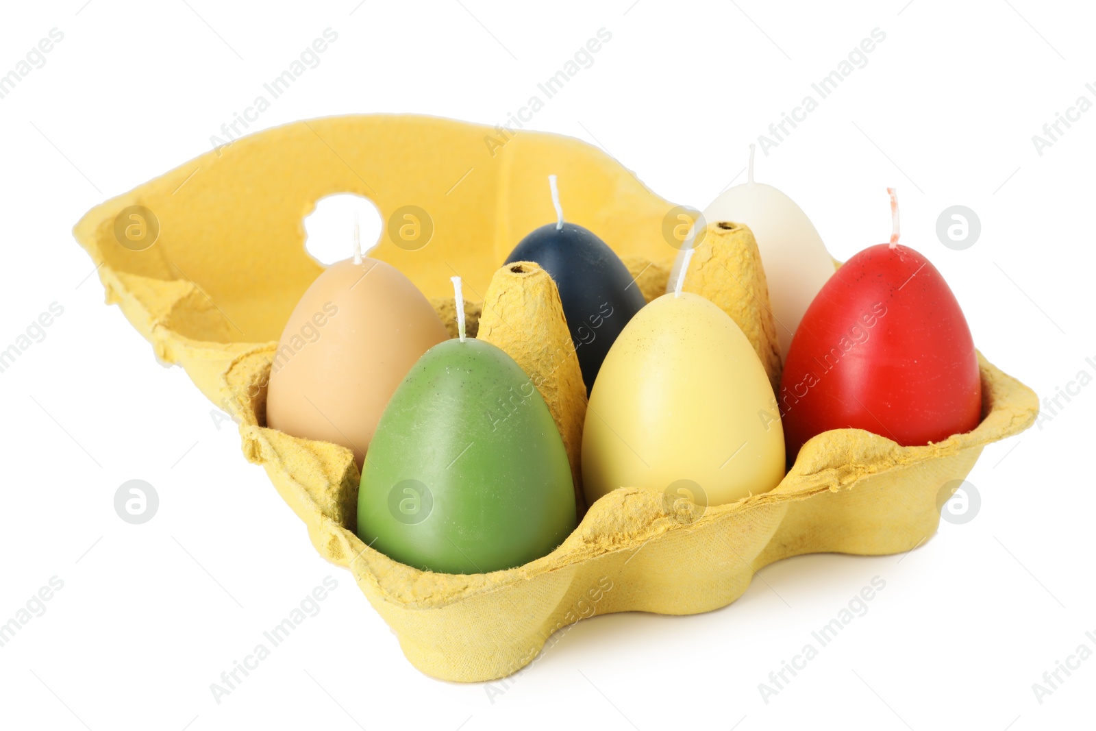 Photo of Colorful egg-shaped candles in carton isolated on white. Easter decor