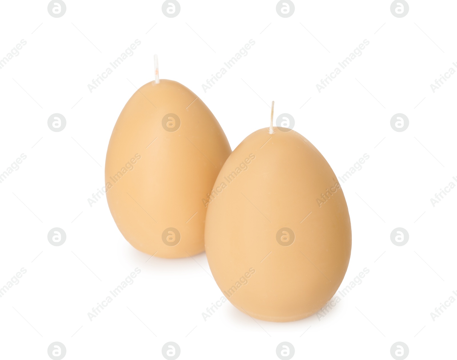 Photo of Egg-shaped candles isolated on white. Easter decor