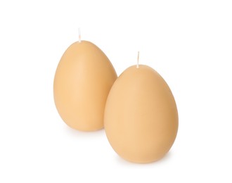 Photo of Egg-shaped candles isolated on white. Easter decor