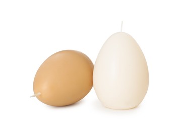 Photo of Egg-shaped candles isolated on white. Easter decor