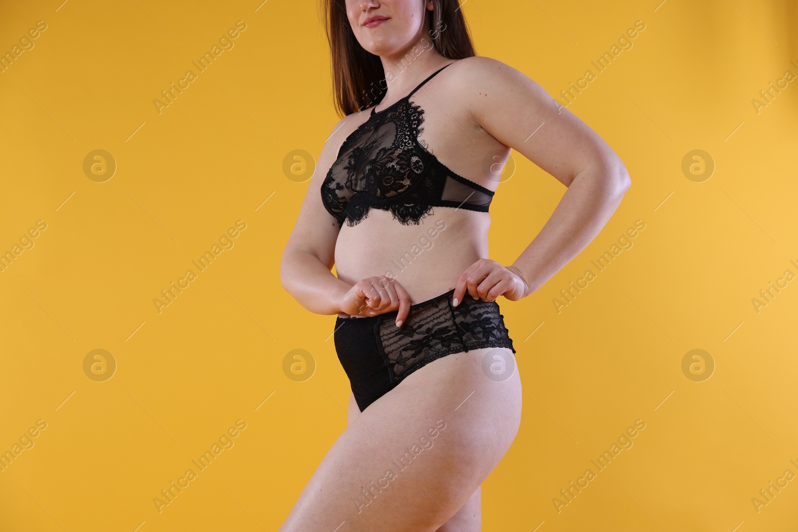 Photo of Woman in underwear on orange background, closeup. Cellulite problem