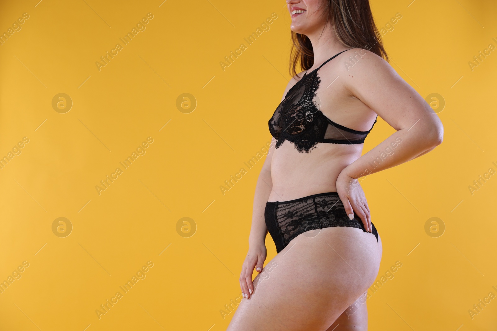 Photo of Cellulite problem. Woman in underwear on orange background, closeup. Space for text