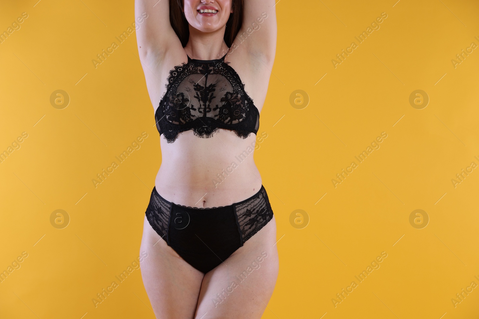 Photo of Woman in underwear on orange background, closeup. Cellulite problem