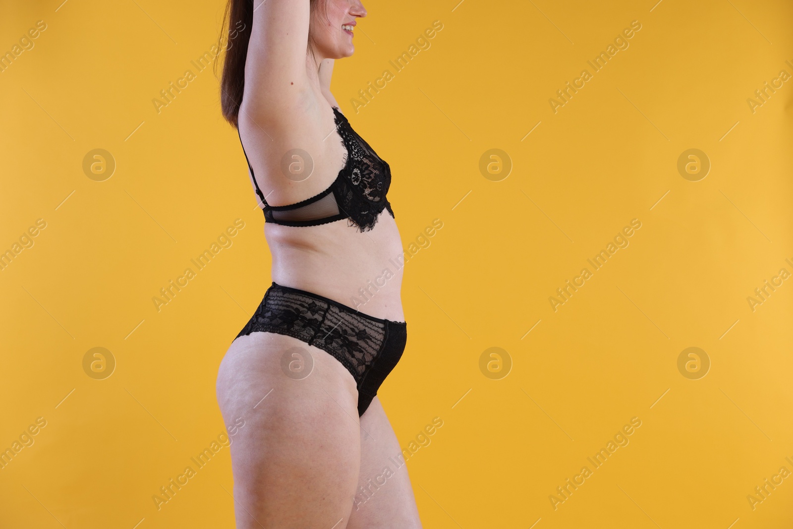 Photo of Cellulite problem. Woman in underwear on orange background, closeup. Space for text