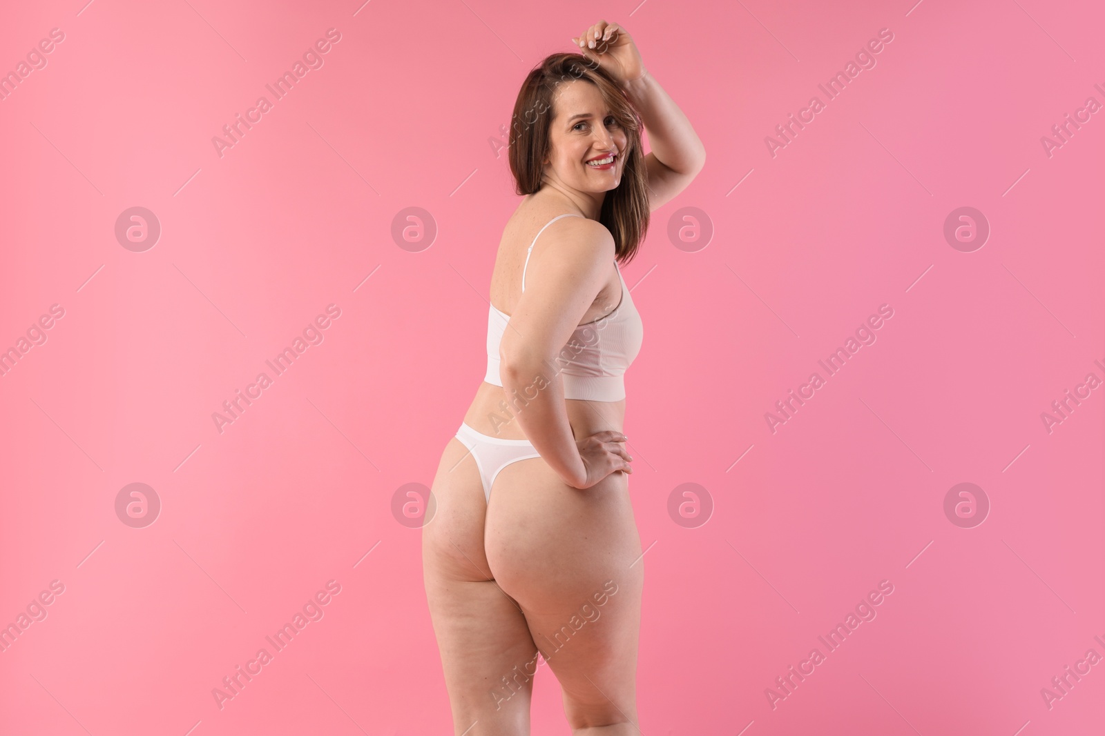 Photo of Woman in underwear on pink background. Cellulite problem