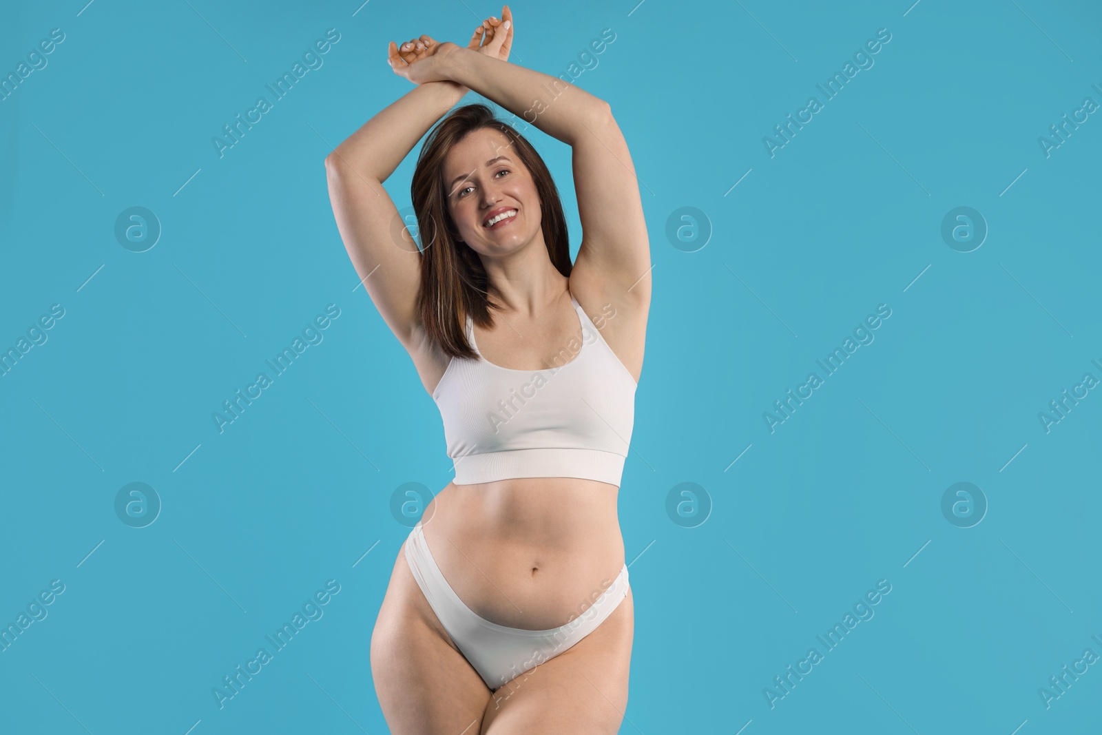 Photo of Woman in underwear on light blue background. Cellulite problem