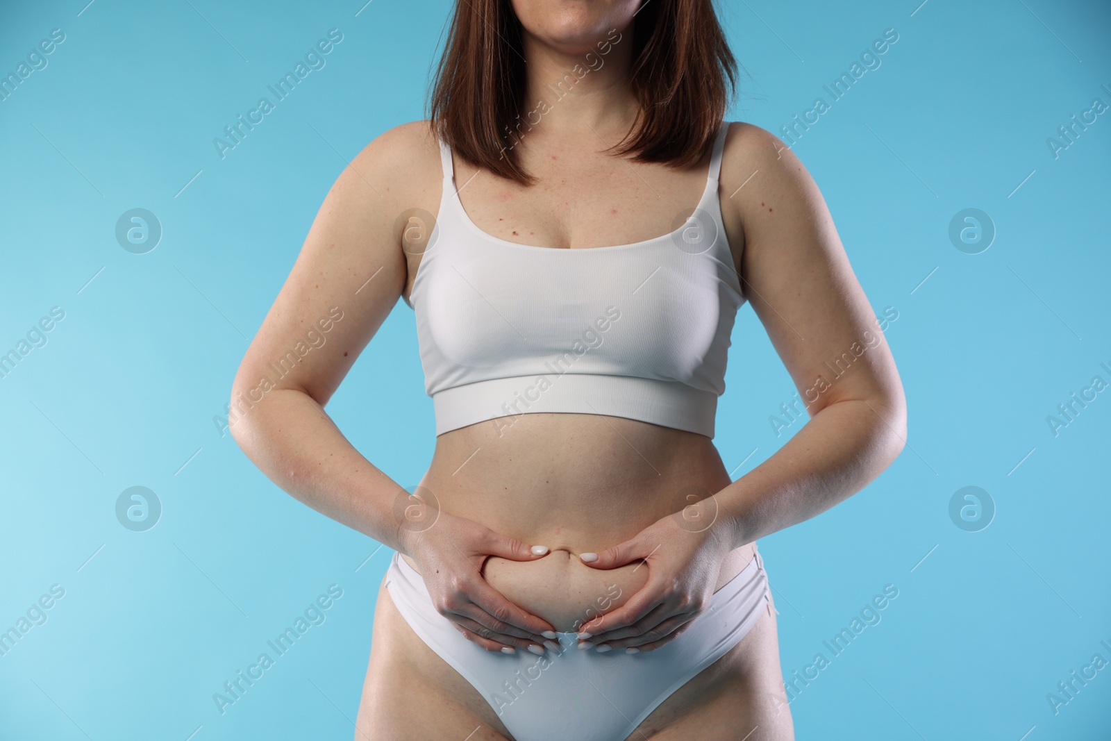 Photo of Woman with cellulite on light blue background, closeup