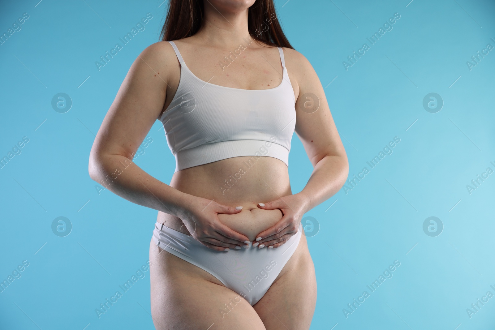 Photo of Woman with cellulite on light blue background, closeup