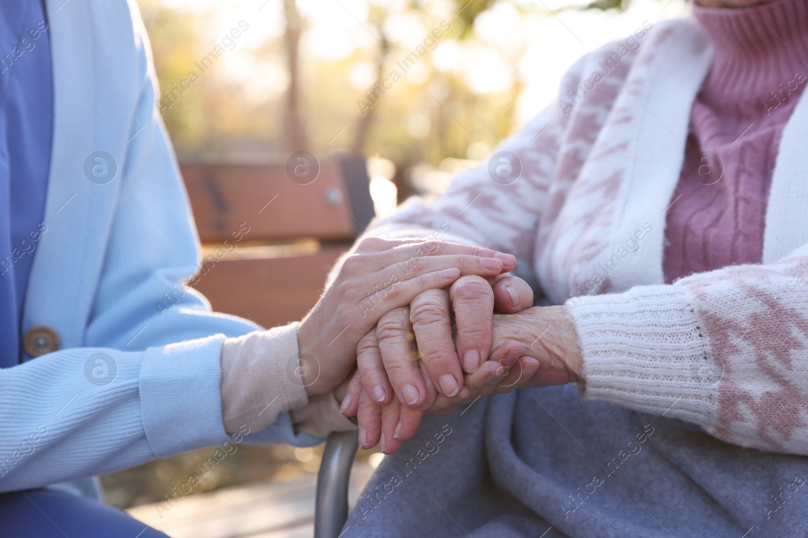 Photo of Caregiver with elderly woman in park, closeup