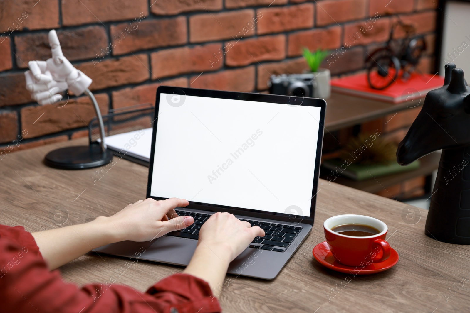 Photo of Woman working with laptop at table in office, closeup