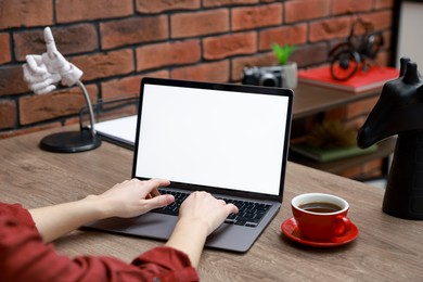 Photo of Woman working with laptop at table in office, closeup