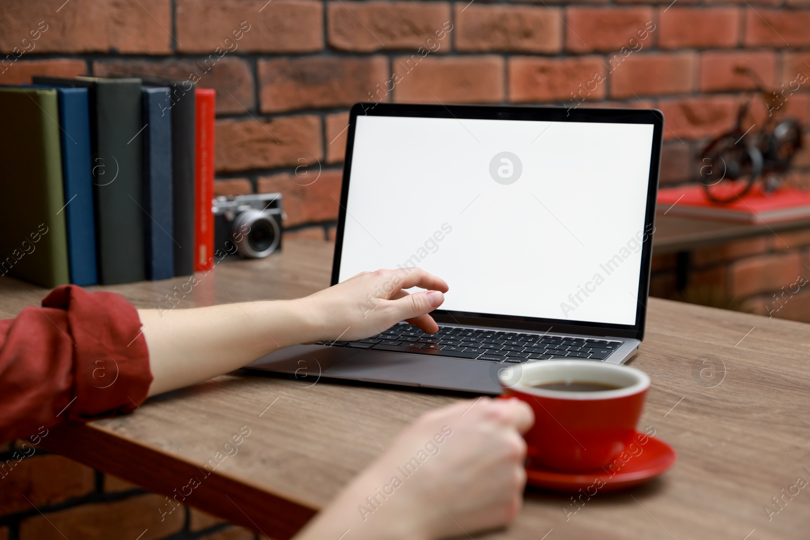 Photo of Woman working with laptop at table in office, closeup