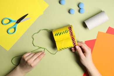 Photo of Woman making craft on green background, top view