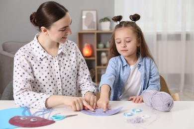 Woman and little girl making paper jellyfish at home. Child handmade craft