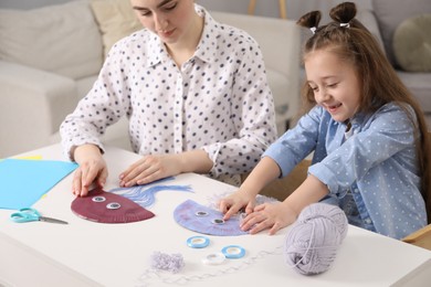 Woman and little girl making paper jellyfish at home. Child handmade craft