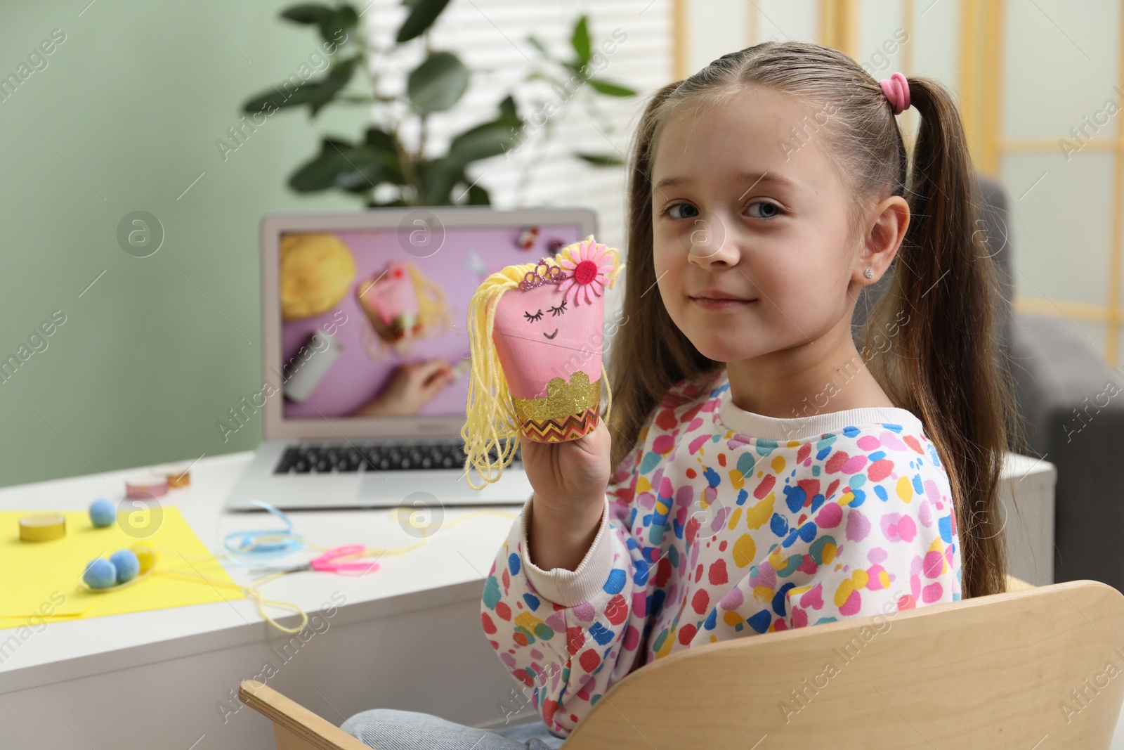 Photo of Little girl with handmade toy at home. Child creativity and craft