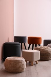 Photo of Different stylish poufs and ottomans in room, space for text