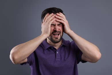 Portrait of sad man crying on grey background