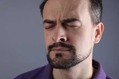 Sad man crying on grey background, closeup. Space for text