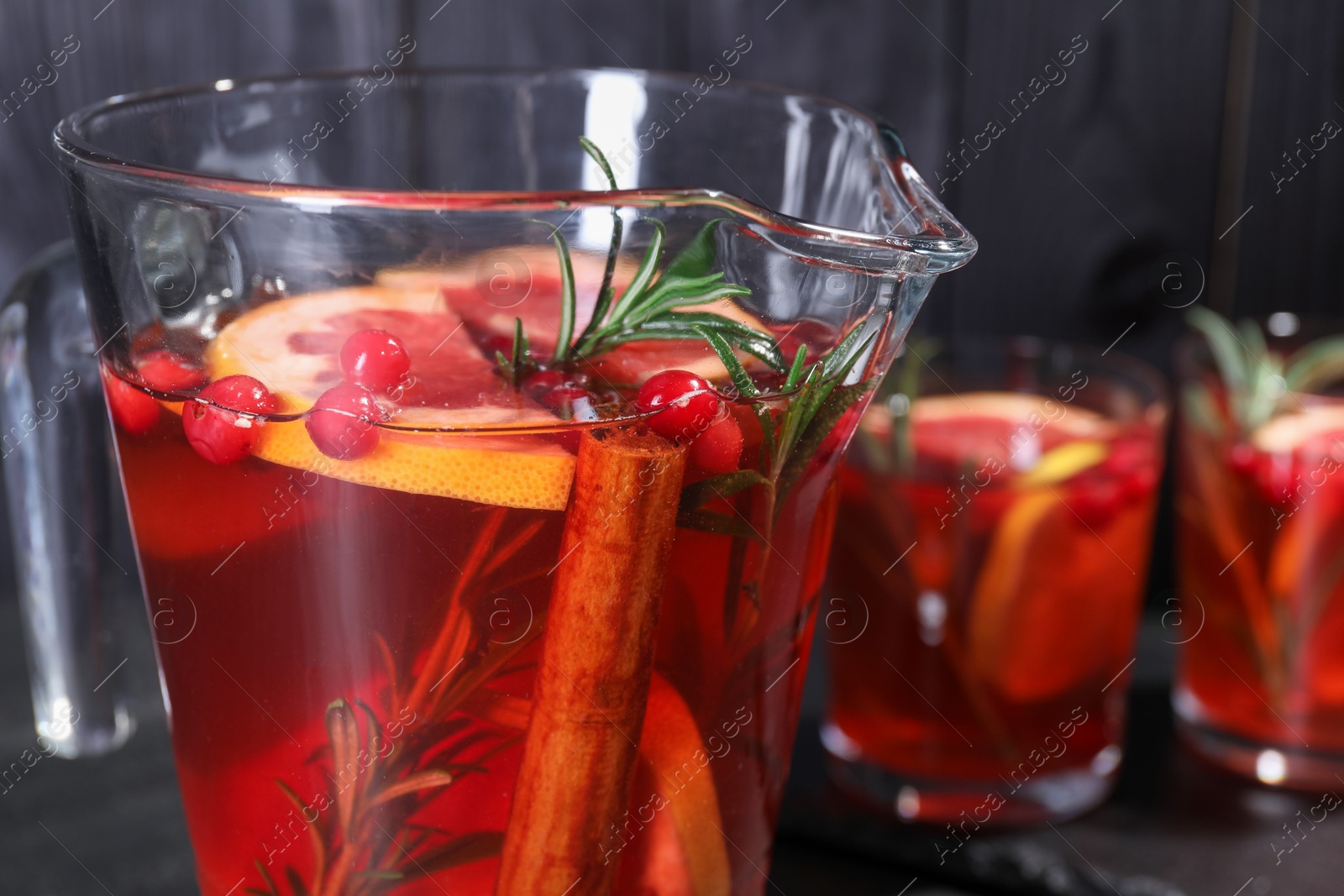 Photo of Delicious punch with rosemary in jug, closeup