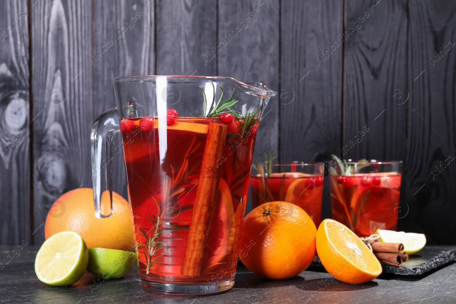 Photo of Delicious punch and ingredients on black table