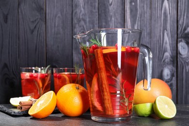 Photo of Delicious punch and ingredients on black table