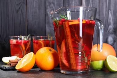 Photo of Delicious punch and ingredients on black table