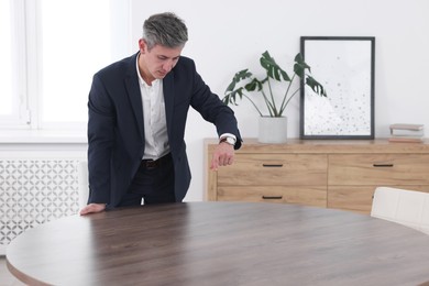 Man pointing at something on desk in office. Space for text