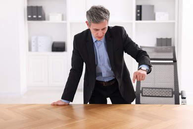 Photo of Man showing something at desk in office