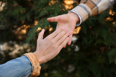 Photo of Help and support. People holding hands outdoors, closeup