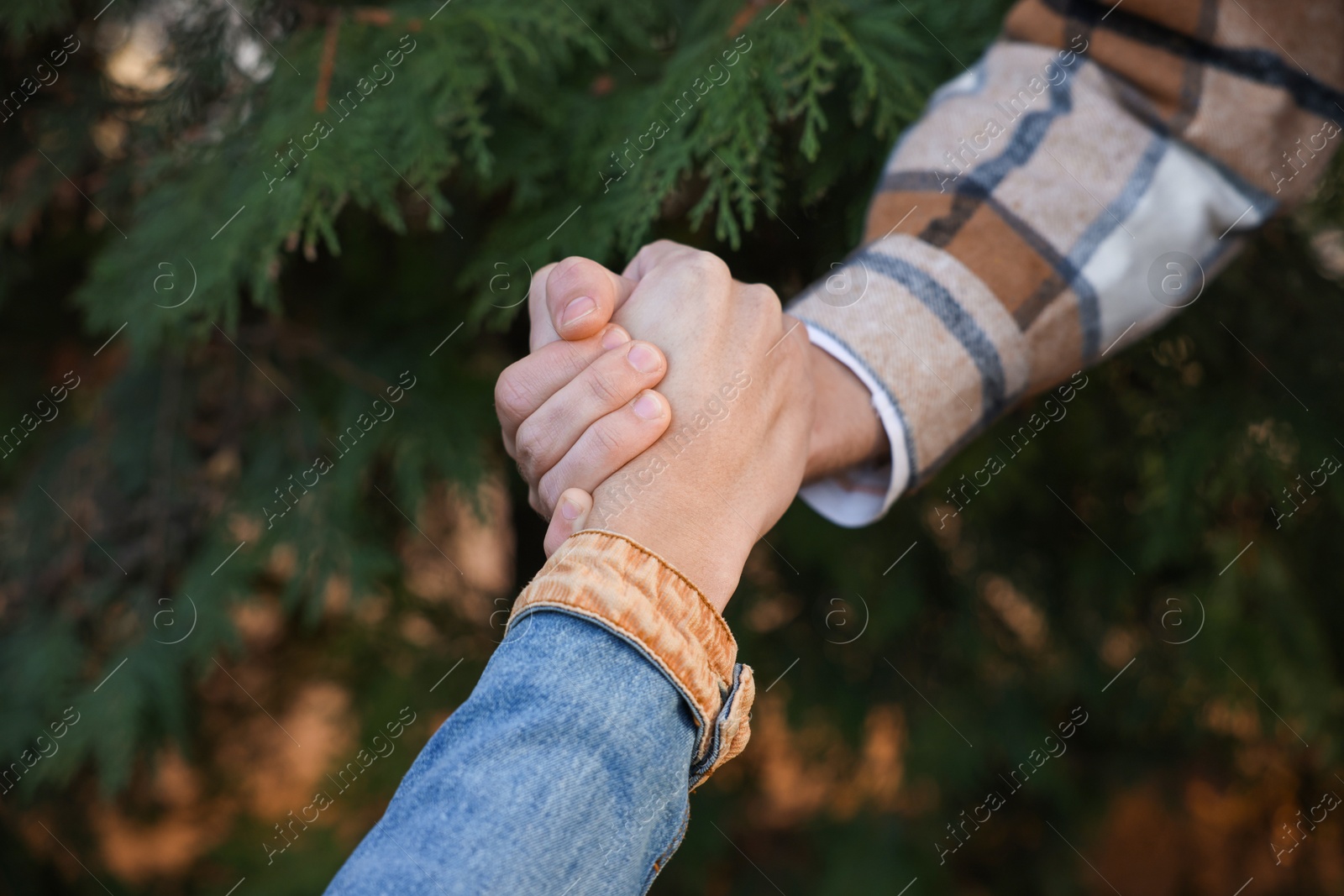 Photo of Help and support. People holding hands outdoors, closeup