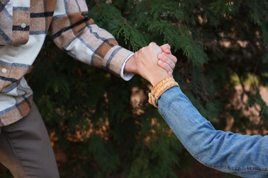 Photo of Help and support. People holding hands outdoors, closeup