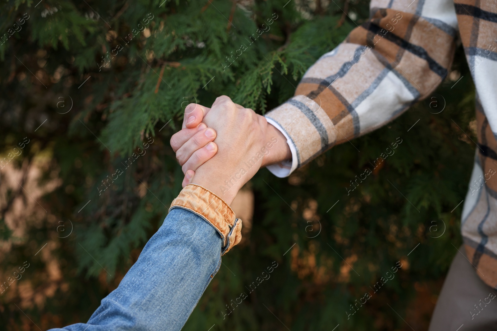 Photo of Help and support. People holding hands outdoors, closeup