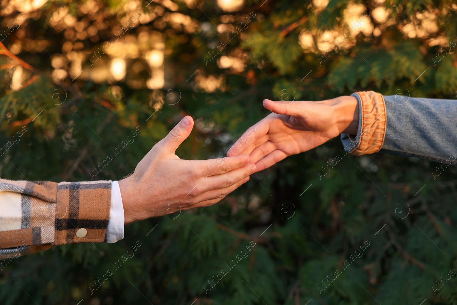 Photo of Man reaching for helping hand outdoors, closeup