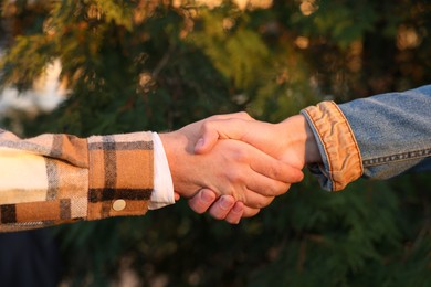 Photo of Help and support. People holding hands outdoors, closeup