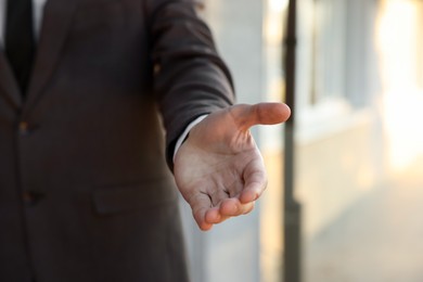 Photo of Man offering helping hand on city street, closeup