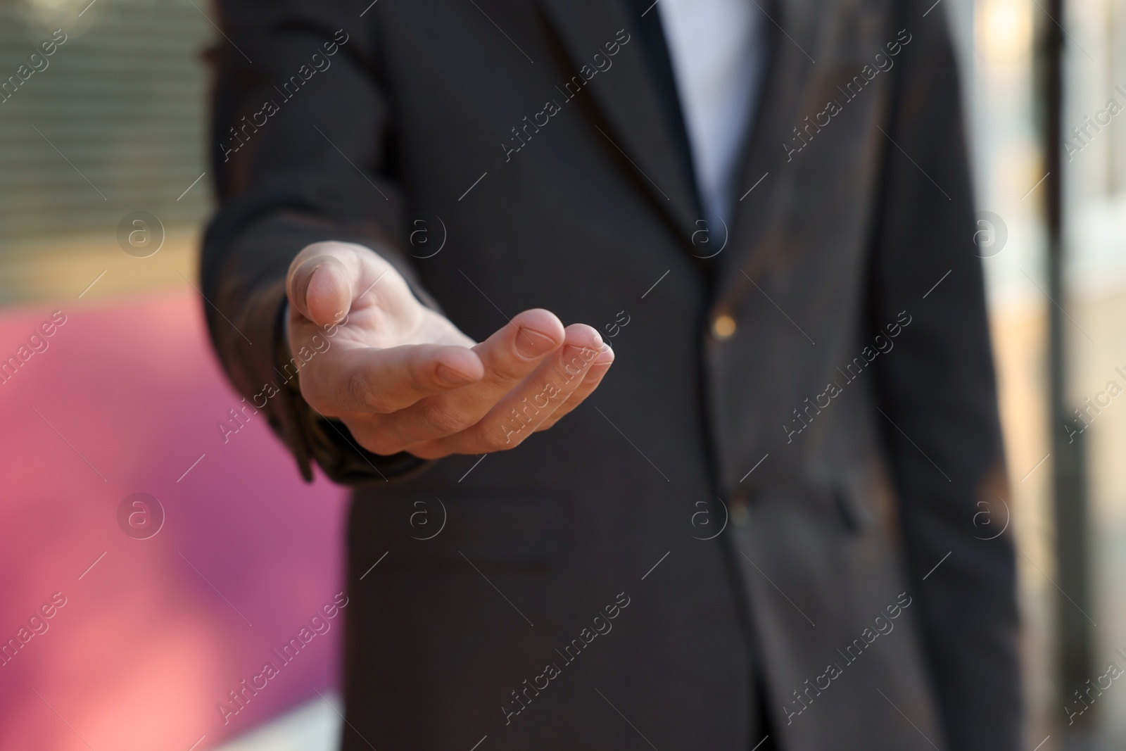 Photo of Man offering helping hand on city street, closeup