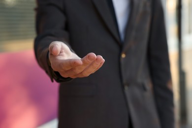 Photo of Man offering helping hand on city street, closeup