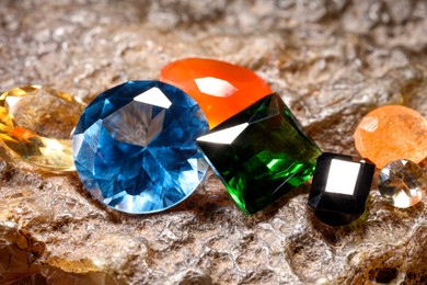 Photo of Beautiful shiny colorful gemstones on rock, closeup